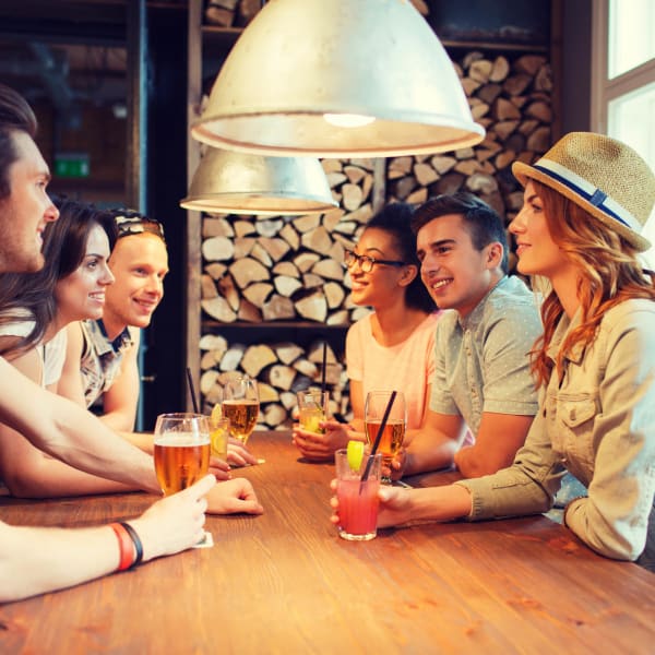 Resident friends enjoying drinks at their favorite spot near Mosaic Dallas in Dallas, Texas