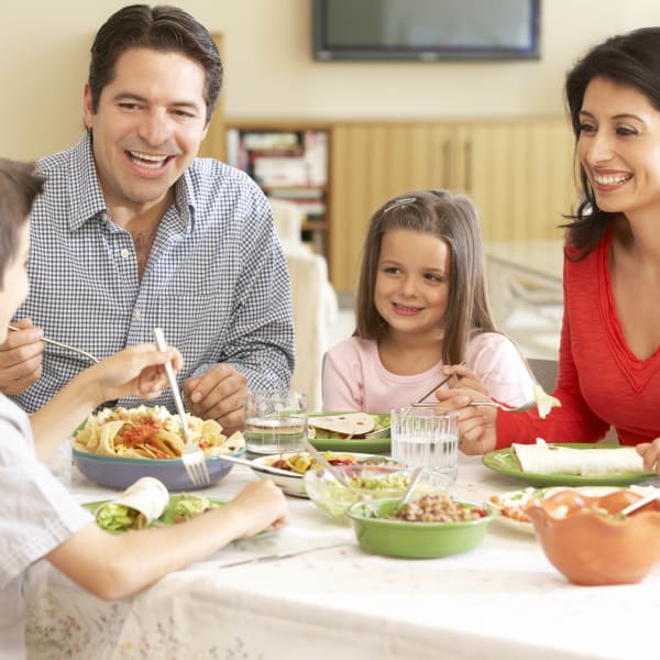 Family enjoying a fantastic meal in their new home at Highland View Court in Bakersfield, California