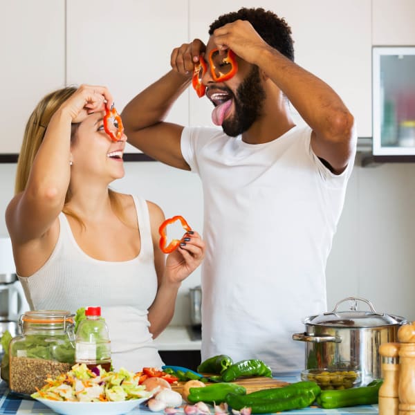 Resident couple having fun with food in their new kitchen at The Hawthorne in Jacksonville, Florida