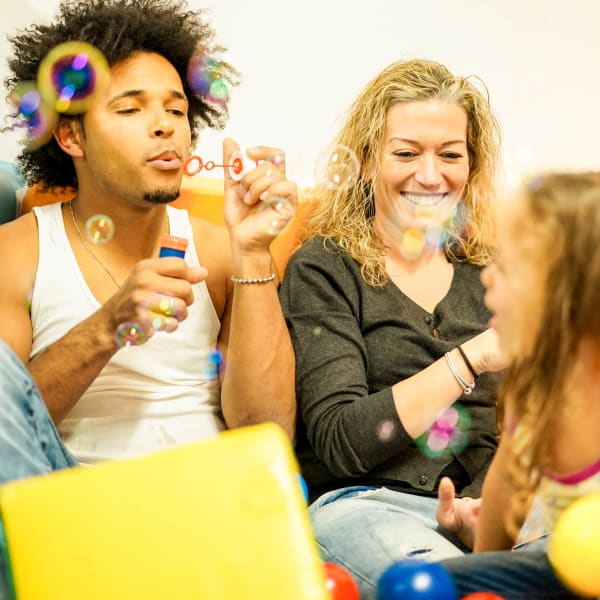 Family blowing bubbles at the fun center near Olympus Court Apartments in Bakersfield, California