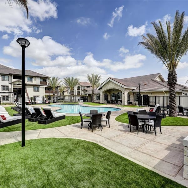 Resort style swimming pool surround by a grass lawn for sunbathing at The Palms at Morada in Stockton, California