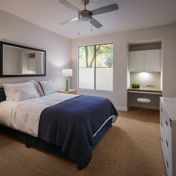 Well-decorated master bedroom with ceiling fan and en suite bathroom at Stone Oaks in Chandler, Arizona