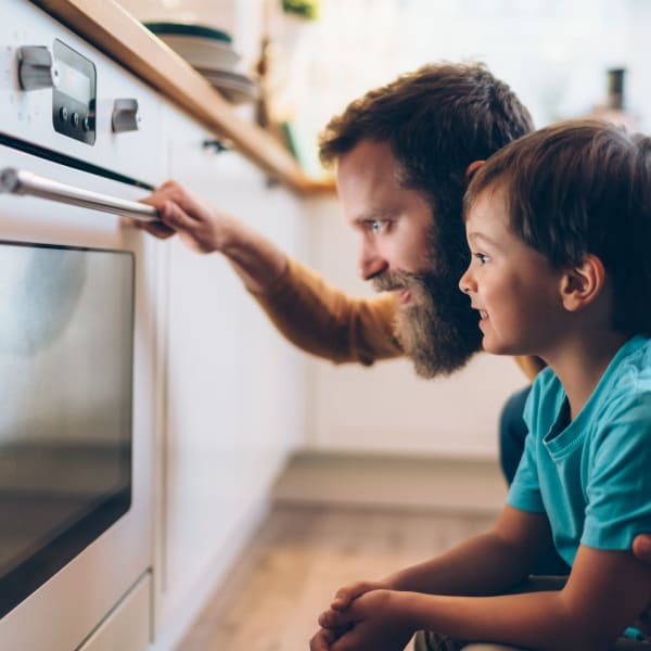 Resident and his son looking into the oven at The Everett at Ally Village in Midland, Texas