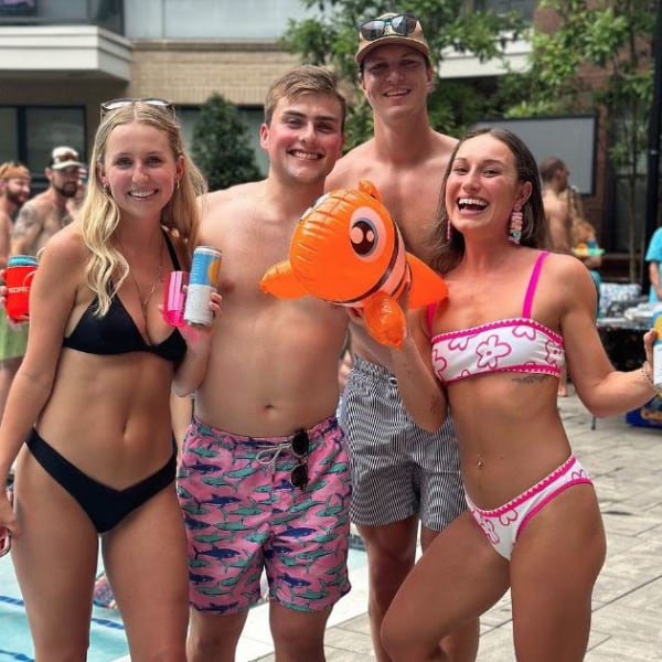 Two couples wearing swimwear posing for a picture near the swimming pool at Revel Ballpark in Smyrna