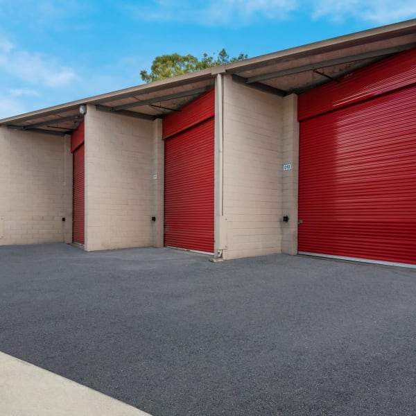 Large outdoor storage units with bright doors at StorQuest Self Storage in Carson, California