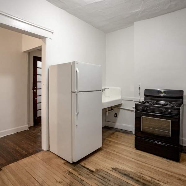 Kitchen with wood-style flooring and white fridge at Detroit Living in Detroit,Michigan
