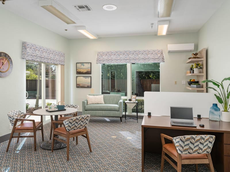 Well lit model unit with dining nook and desk at Blossom Vale Senior Living in Orangevale, California. 