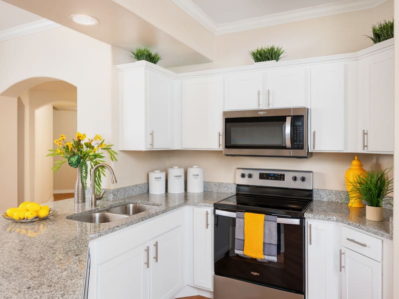 Kitchen with white cabinets and stainless steel appliances at Villas on Hampton