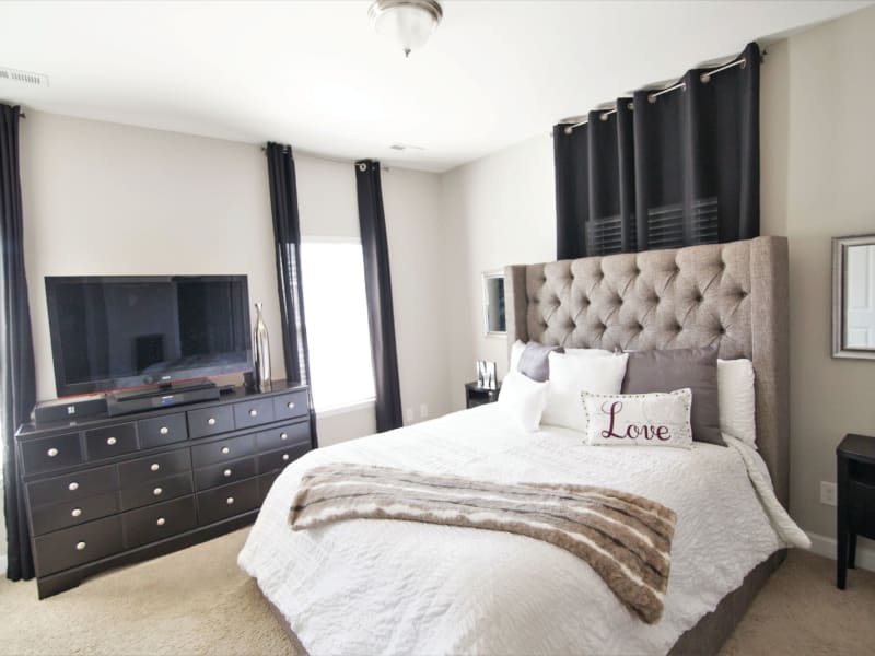 Modern bedroom with beautiful bed frame at Charleston Row Townhomes in Pineville, North Carolina