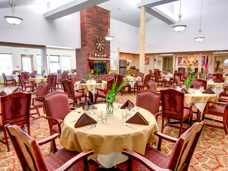 Dining room with a large, brick fireplace at Junction City Retirement and Assisted Living in Junction City, Oregon