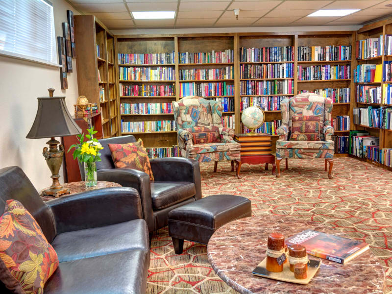 Library with comfortable armchairs for reading at Junction City Retirement and Assisted Living in Junction City, Oregon