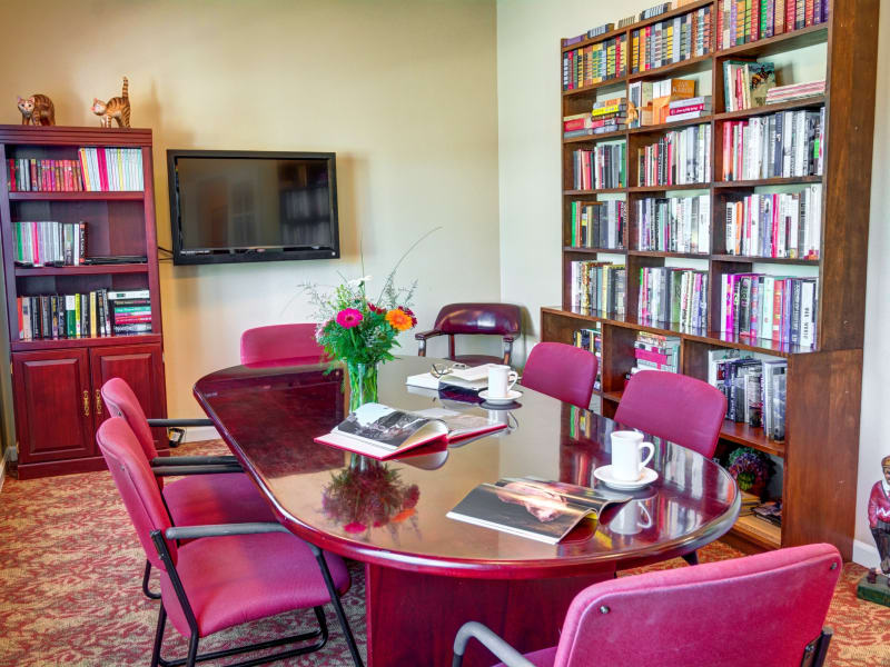 Library with a large table for reading or gathering at Morrow Heights Assisted Living in Rogue River, Oregon