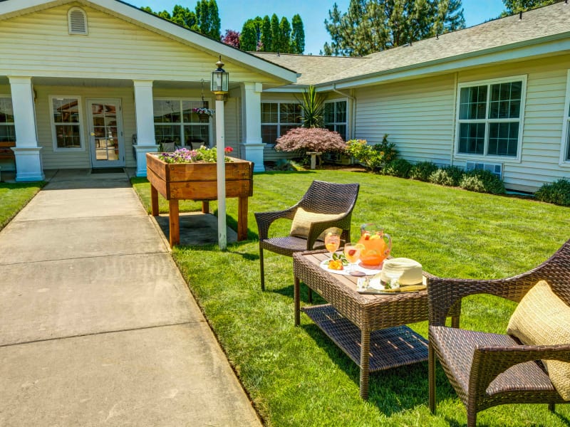 Chairs and table set with a pitcher of lemonade in the courtyard at Morrow Heights Assisted Living in Rogue River, Oregon