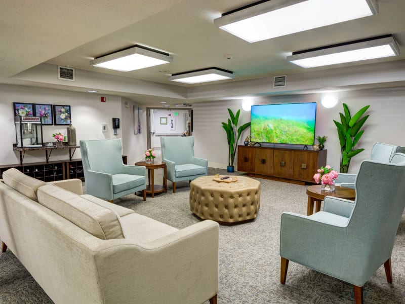 Sitting area with a large sofa, armchairs, and flat screen TV at Silver Creek Senior Living in Woodburn, Oregon