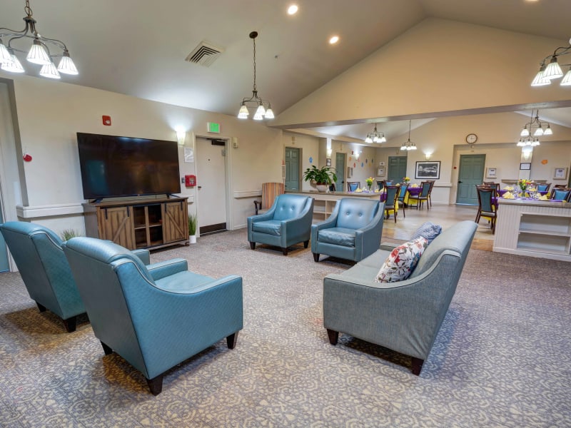 Sitting area with armchairs and a large flat screen TV at Timberwood Court Memory Care in Albany, Oregon