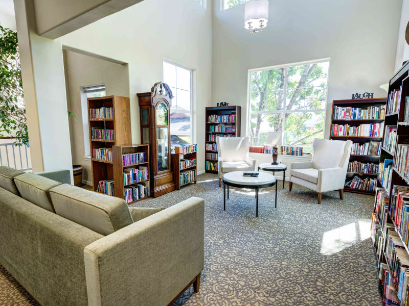 Library with lots of natural light and comfortable seating at Vineyard Heights Assisted Living in McMinnville, Oregon