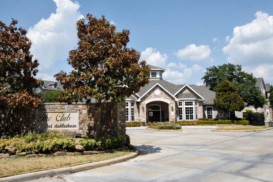 View of our welcoming property sign and leasing office in the background at The Club at Stablechase