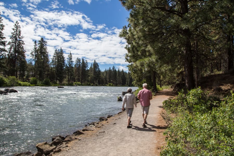 Residents walking the Deschutes river trail at Touchmark at Mount Bachelor Village in Bend, Oregon