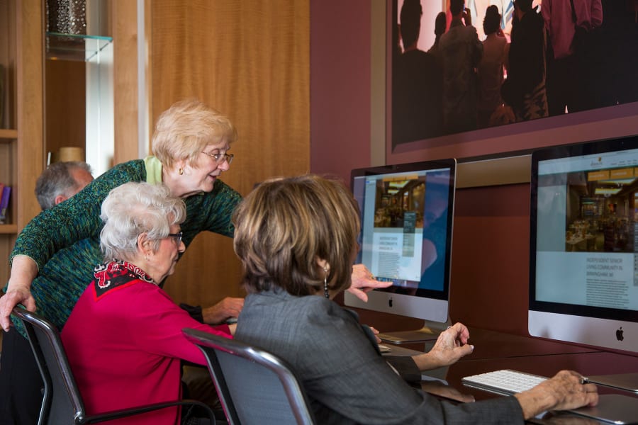 Residents using the Apple computers in the business center at Casa Del Rio Senior Living in Peoria, Arizona