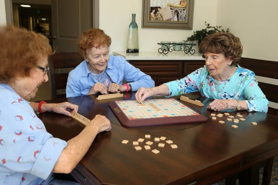 Seniors enjoying a game of scrabble in community lounge at The Commons at Woodland Hills in Woodland Hills, California