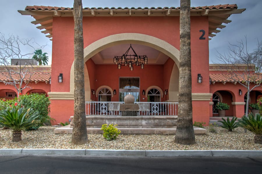 Exterior view of the building facade and landscaping at the entrance to Casa Del Rio Senior Living in Peoria, Arizona