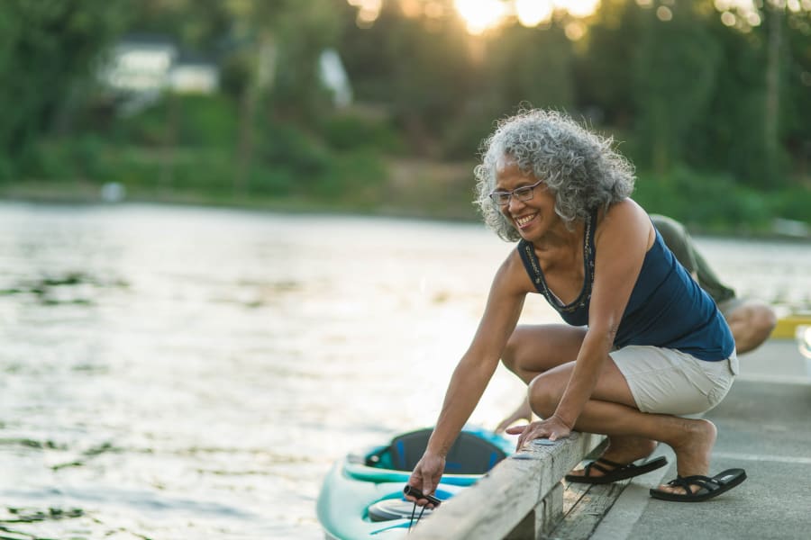 A woman by a lake getting into a kayak near Applewood Pointe of Westminster in Westminster, Colorado.