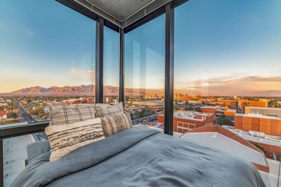 Bedroom with floor-to-ceiling windows and stunning skyline views at a Campus Life & Style Autograph Collection property