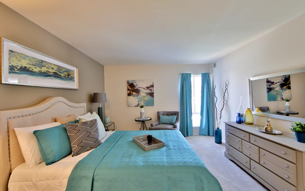 Model bedroom with ensuite bathroom and walk-in closet at Carriage Hill Apartment Homes in Randallstown, Maryland