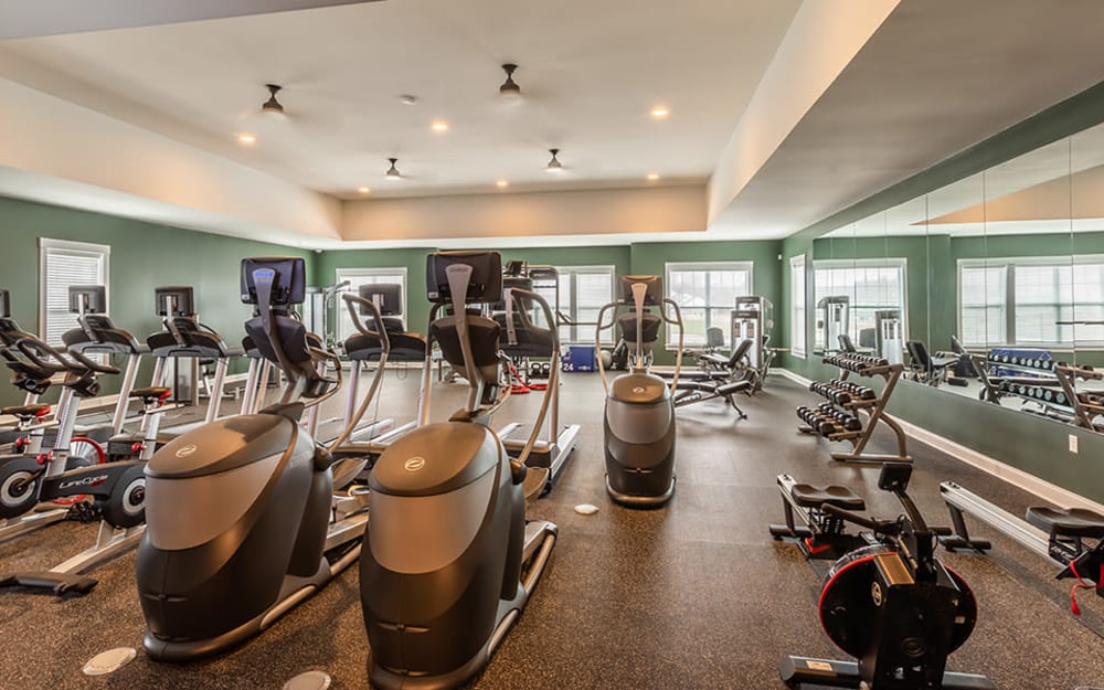 Well-equipped fitness center with cardio equipment at Woodland Acres Townhomes in Liverpool, New York