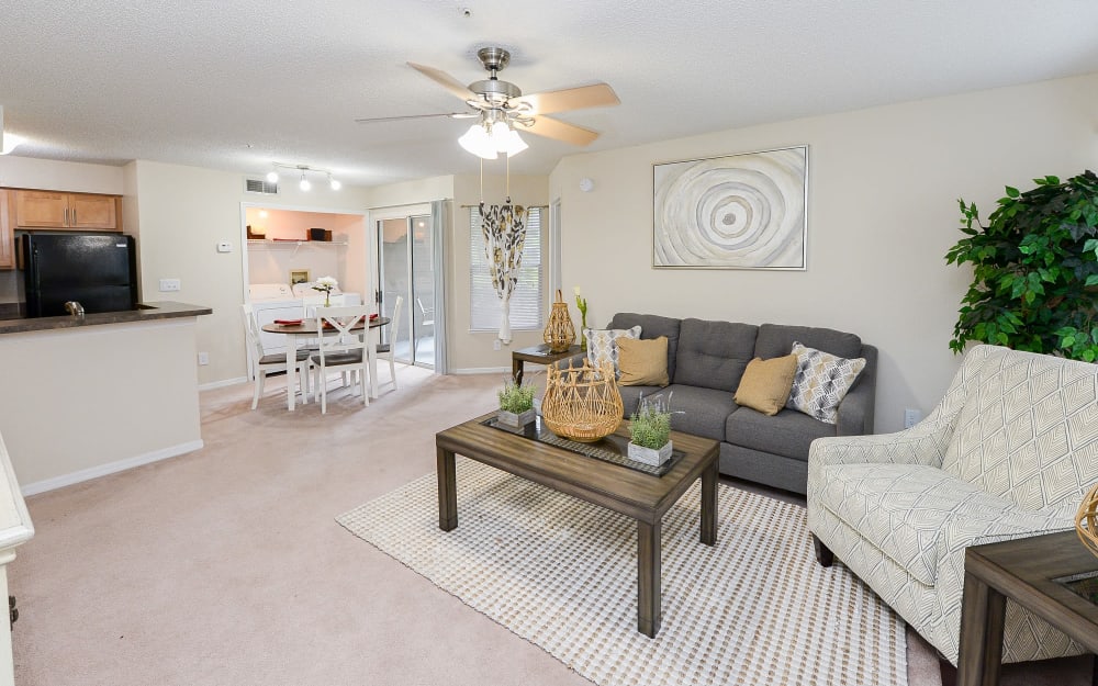 Open layout living room and dining area with pass-through to the kitchen of a model home at Promenade Apartment Homes in Winter Garden, Florida