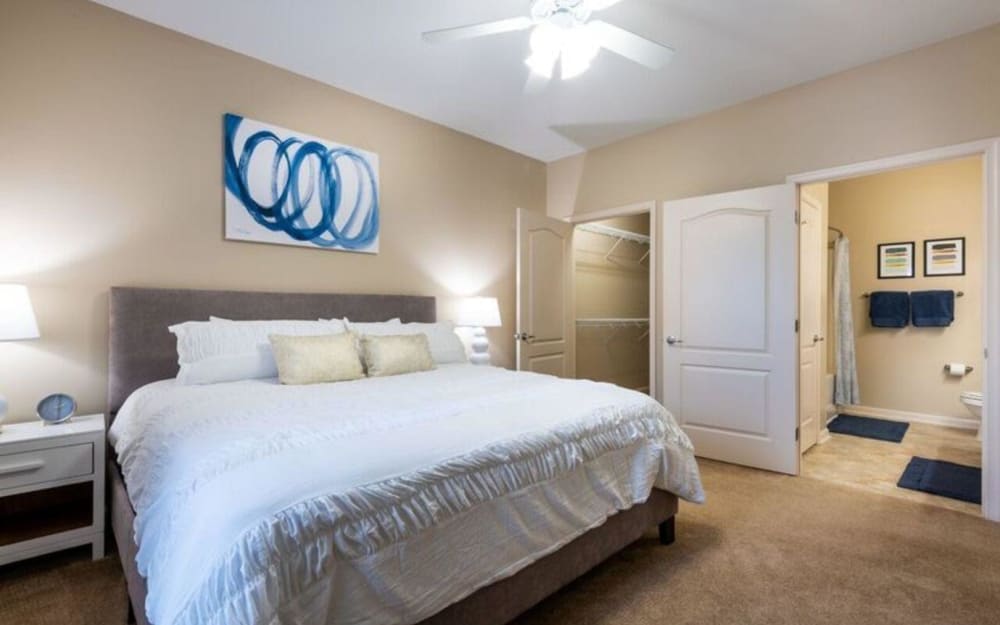 Model bedroom with ensuite bathroom and walk-in closet at Carden Place Apartment Homes in Mebane, North Carolina