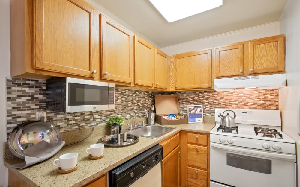 Model kitchen with tile backsplash and a built-in microwave at Westerlee Apartment Homes in Baltimore, Maryland