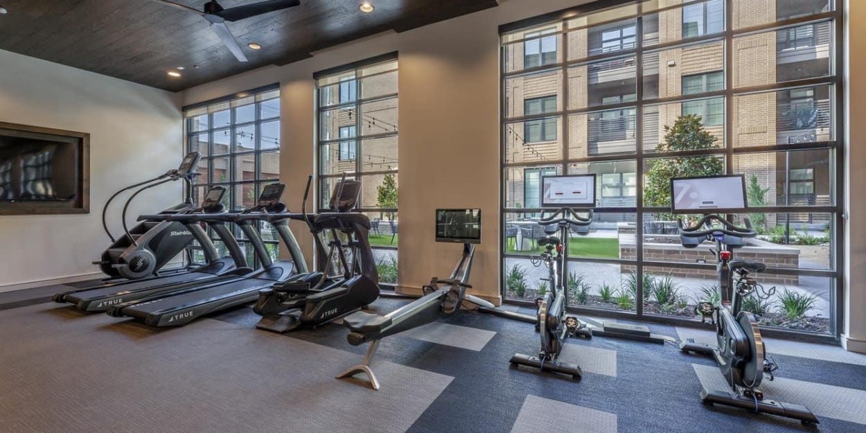 Cardio equipment in the fitness center overlooking the courtyard at Ross + Peak in Dallas, Texas