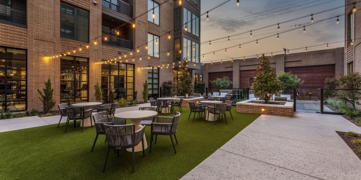 String lights over the courtyard at dusk at Ross + Peak in Dallas, Texas