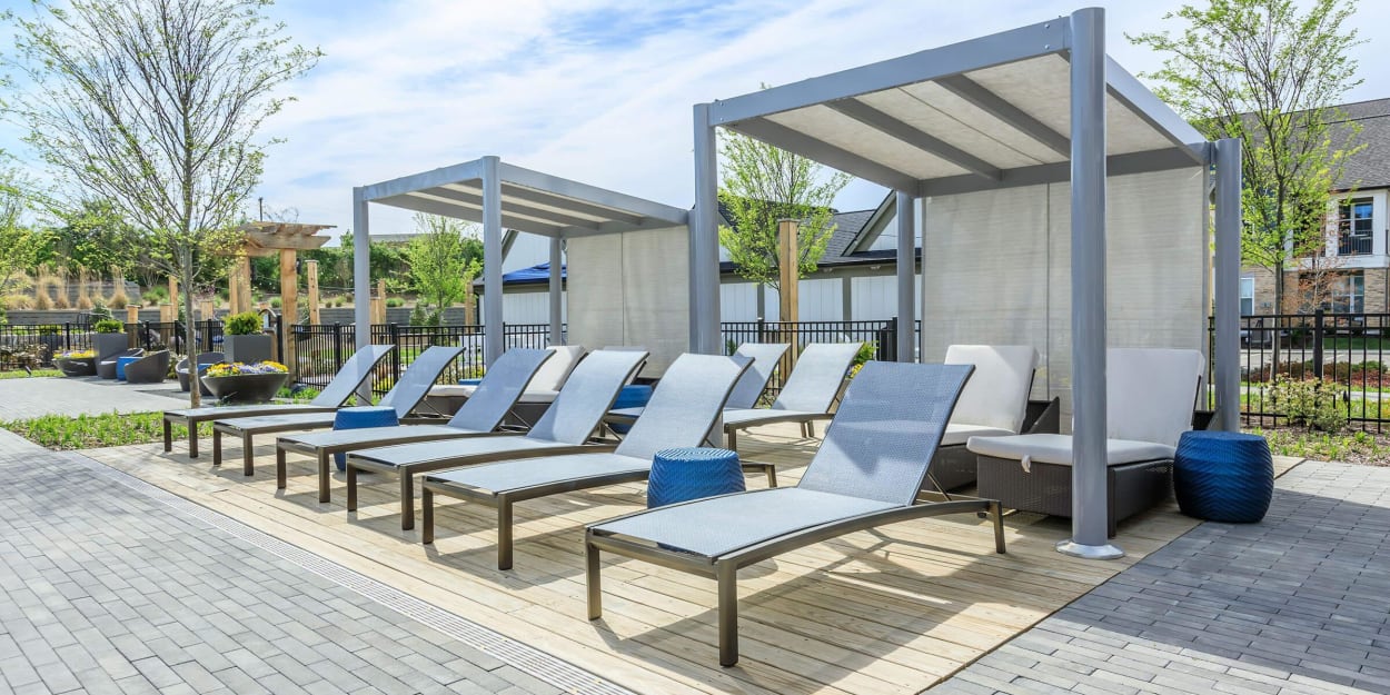 Lounge chairs and covered cabanas by the pool at Mandolin at Stream Valley in Franklin, Tennessee