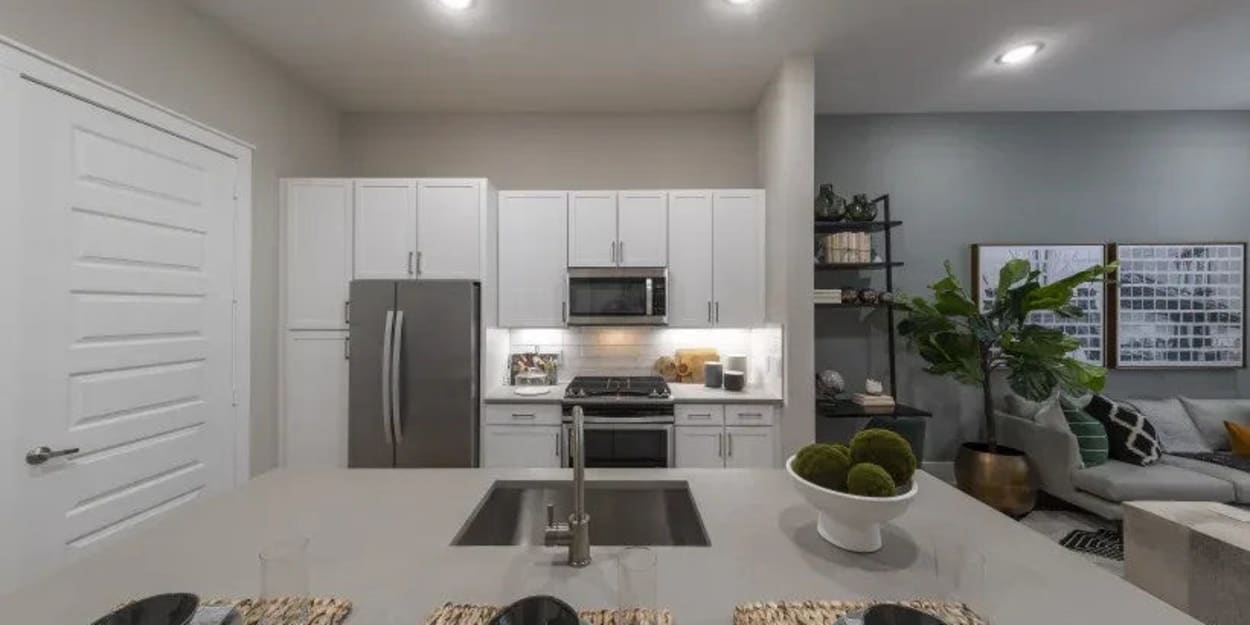 Kitchen with an island and stainless-steel appliances at The Register in Richardson, Texas