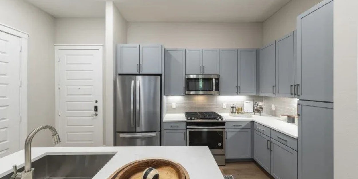 Apartment kitchen with stainless-steel appliances at The Register in Richardson, Texas
