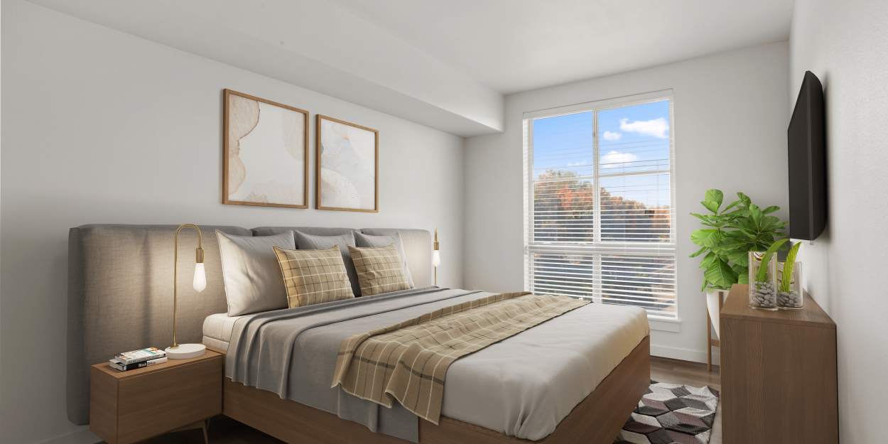 A bedroom with a large window at The Meadowlark at Fairview in Fairview, Oregon