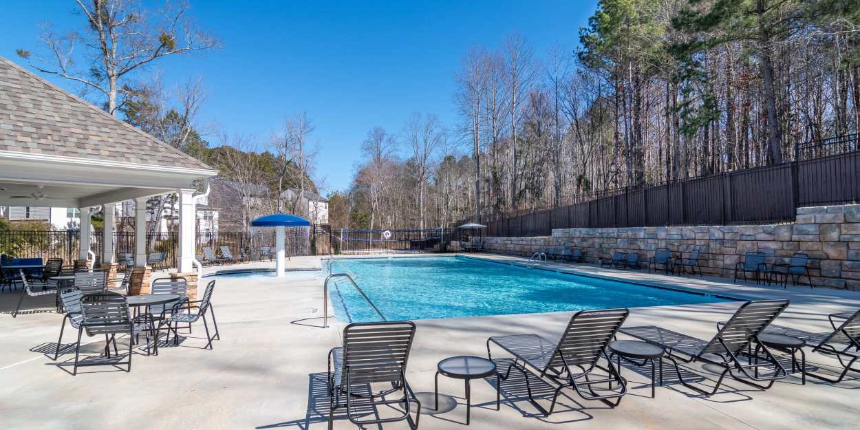 Outdoor pool with lounge chairs and a covered seating area The Lakes at Statham in Statham, Georgia