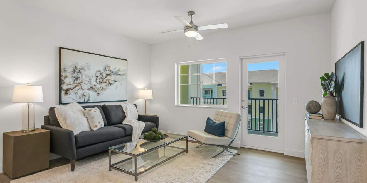Living room with a door out to a private patio at Grand Oak Apartments in Largo, Florida