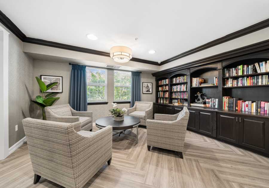 Sitting area with book shelves at Waltonwood Royal Oak in Royal Oak, MI