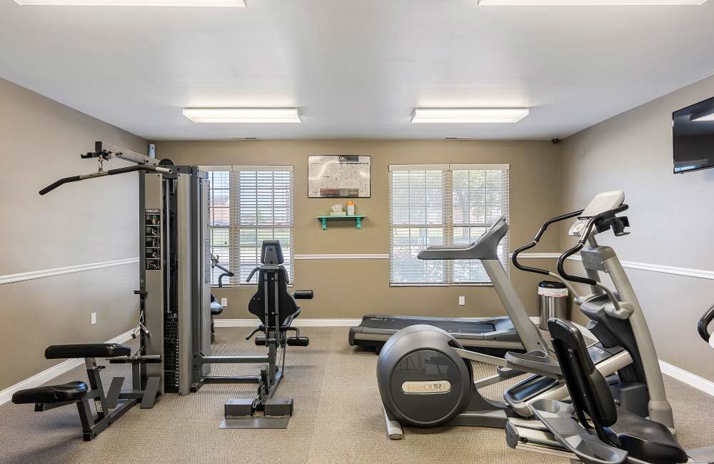 Windows with blinds and fitness equipment at Indian Footprints Apartments in Harrison, Ohio