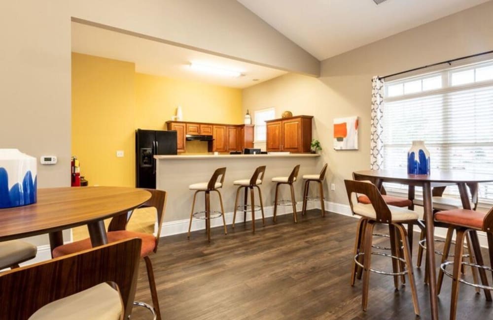 Kitchen with counter seating and a couple of bistro tables in the clubhouse at Carden Place Apartment Homes in Mebane, North Carolina