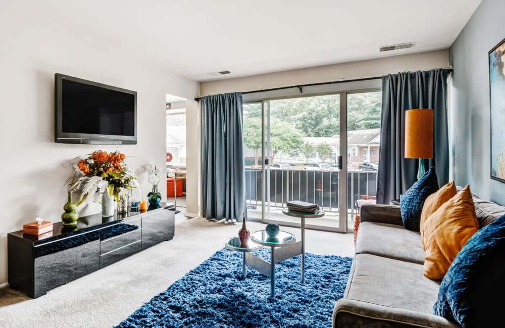 Spacious model living room with sliding door access to a private balcony at Avery Park Apartment Homes in Silver Spring, Maryland