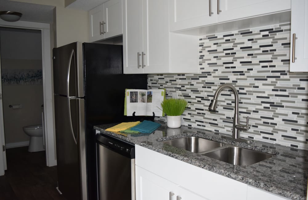 Modern kitchen with tile backsplash and white cabinetry at The Preserve on Allisonville in Indianapolis, Indiana