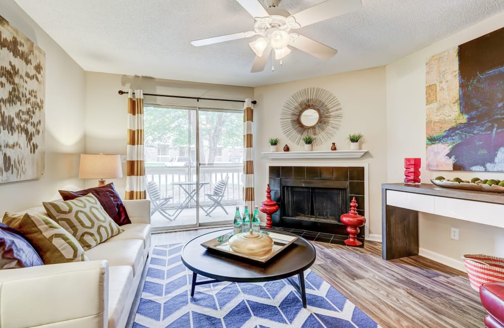 Living room with a fireplace and balcony access at Hampton Greene Apartment Homes in Columbia, South Carolina