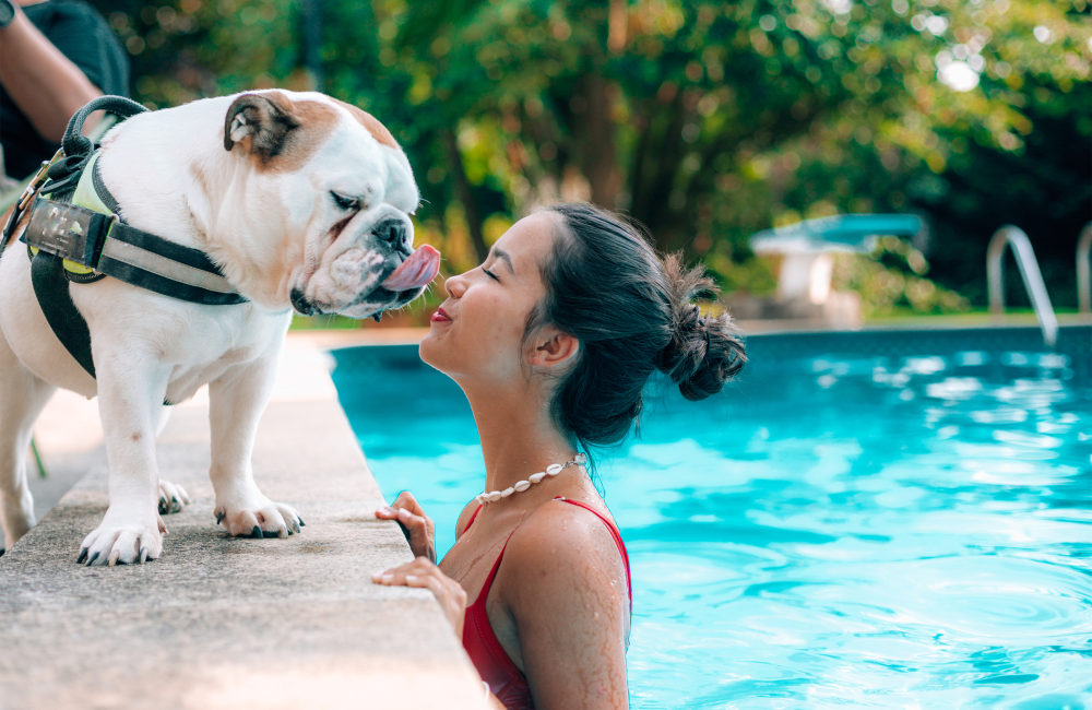 Resident swimming and kissing her pup at Marshall Apartment Homes in Balch Springs, Texas