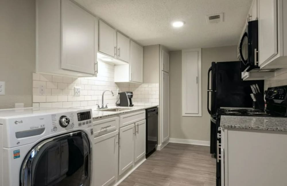 Apartment kitchen with dishwasher and white cabinetry at Array in Austin,Texas