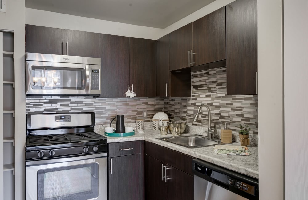 Modern kitchen with stainless steel appliances at East Meadow Apartments in Fairfax, Virginia