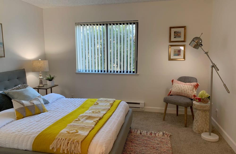 Cozy bedroom with area rug in a model home at Point Alameda in Alameda, California